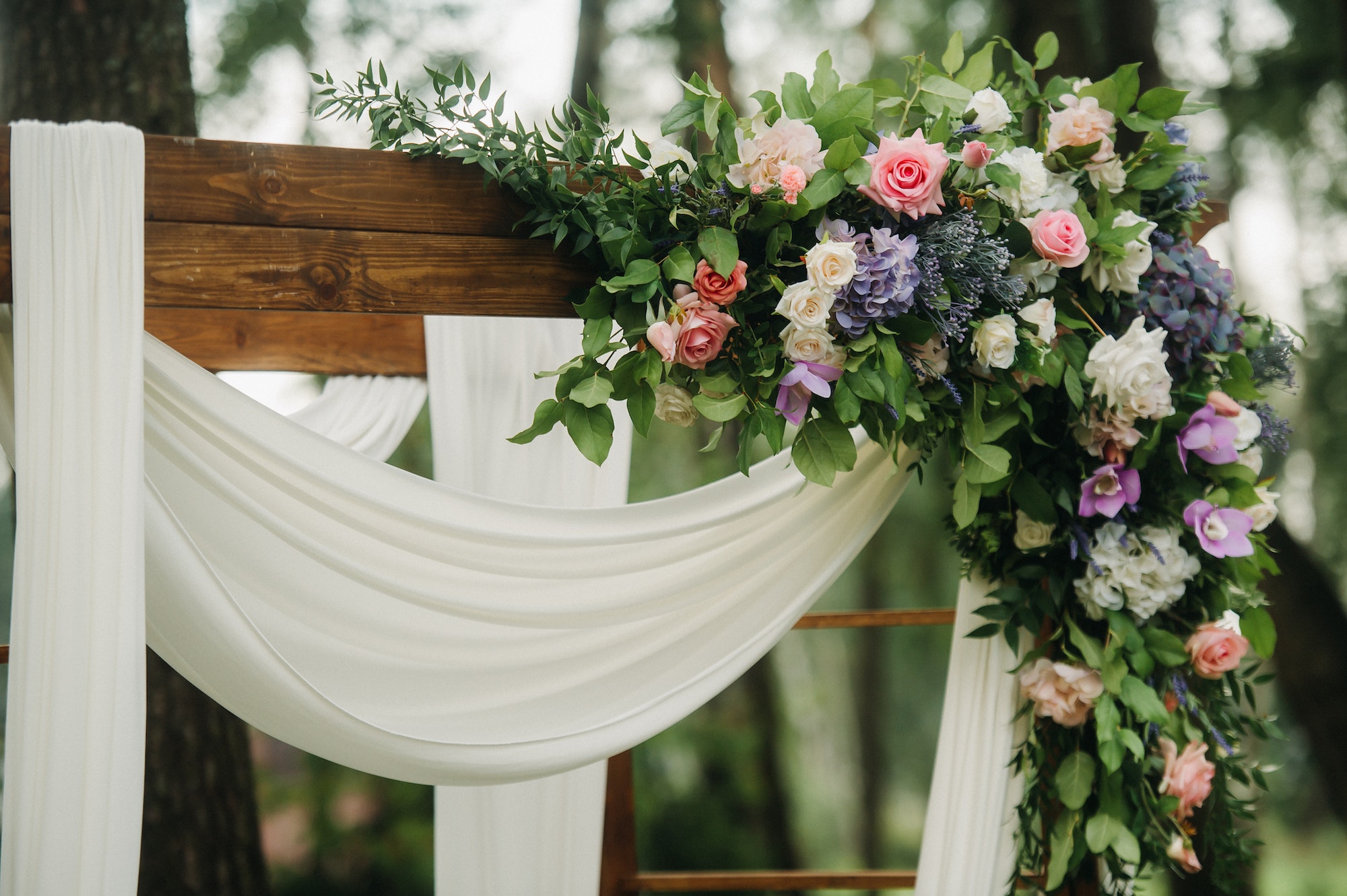Wedding ceremony on the street on the green lawn.Decor with fresh flowers arches for the ceremony